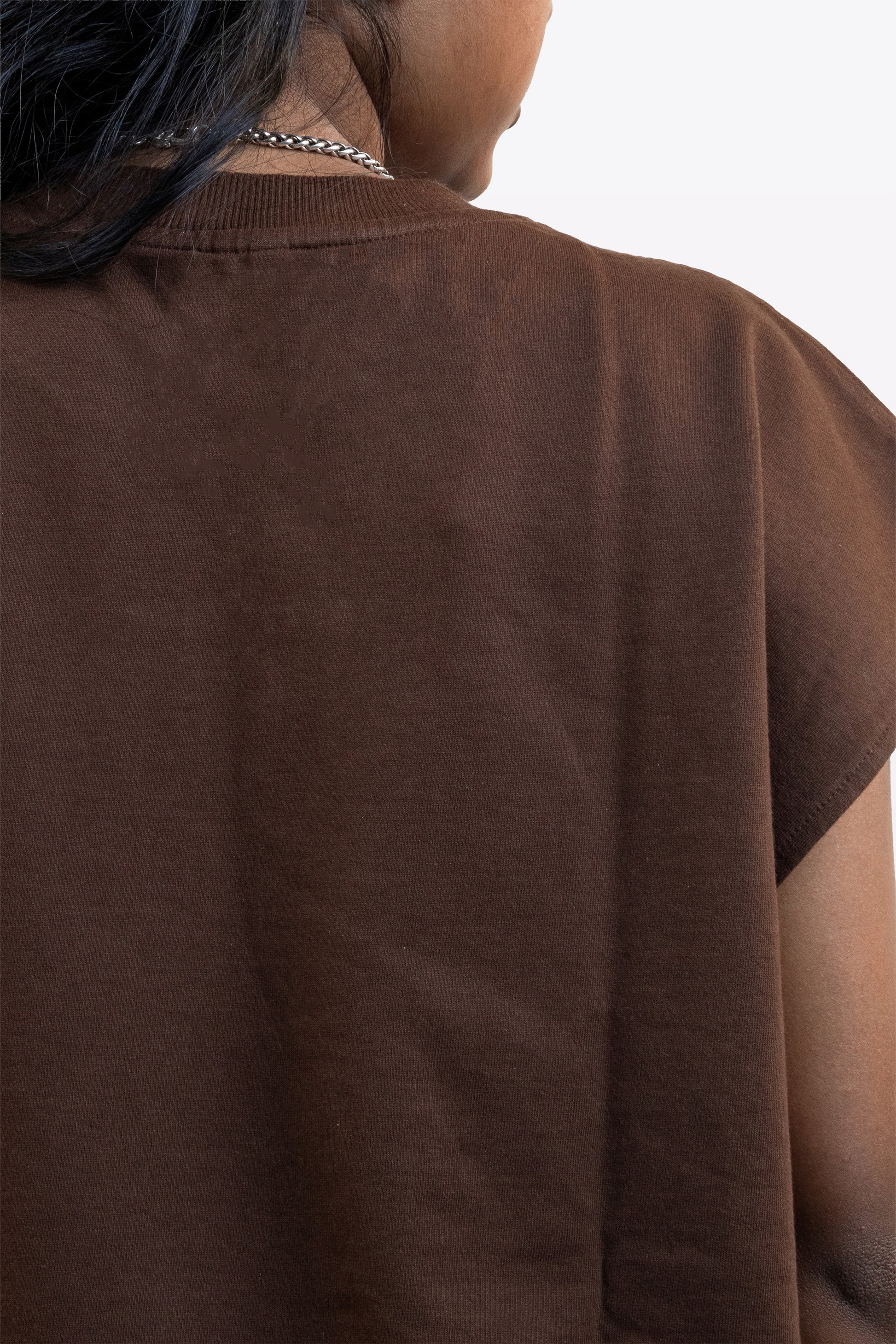 A model wearing a cacao brown sleeveless top, back view, on a white background.