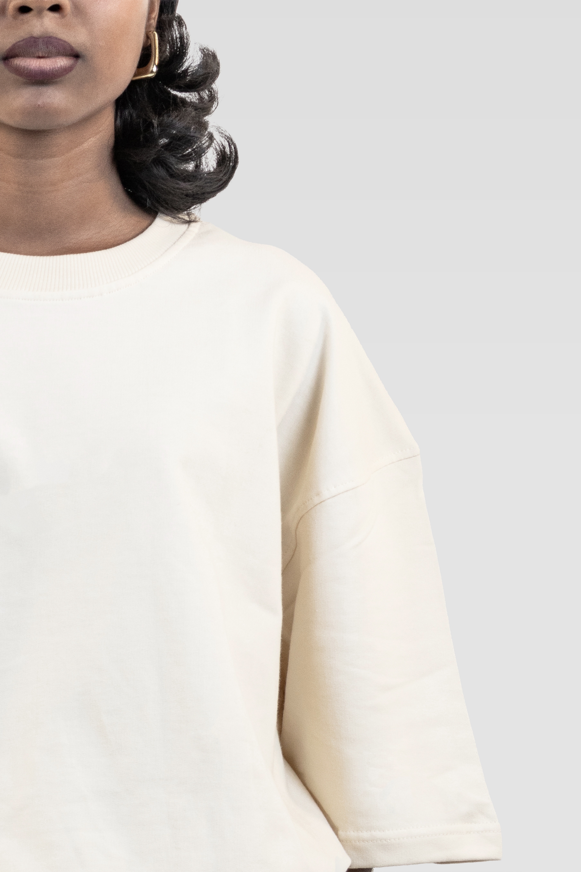 Front close-up of a model wearing Harper Slein Off White oversized tee in premium 240 GSM cotton, highlighting the ribbed neckline, clean seams, and soft drape against a plain background.