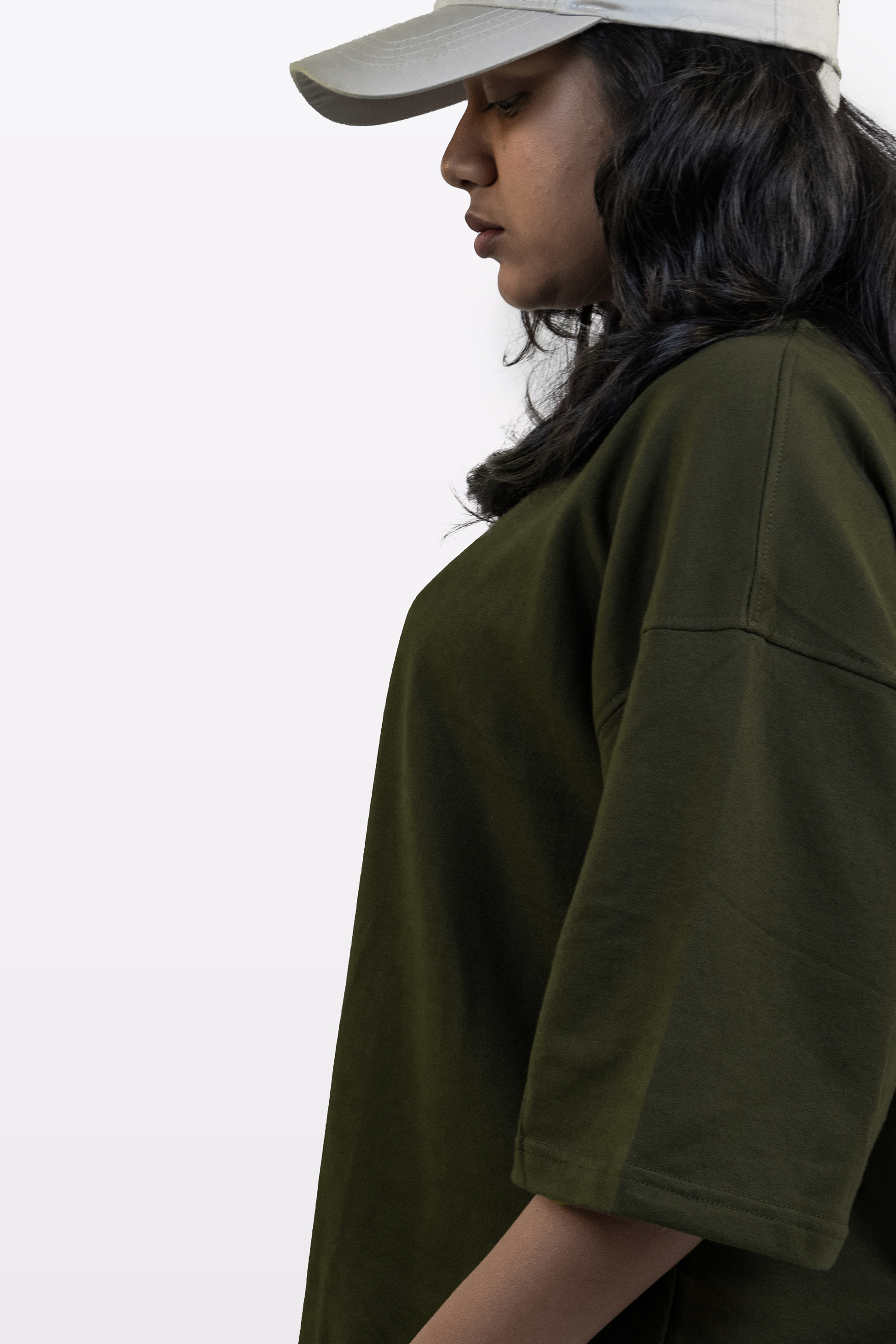 Side profile of a female model wearing the Harper Slein oversized t-shirt in Nori Seaweed Green against a white background.