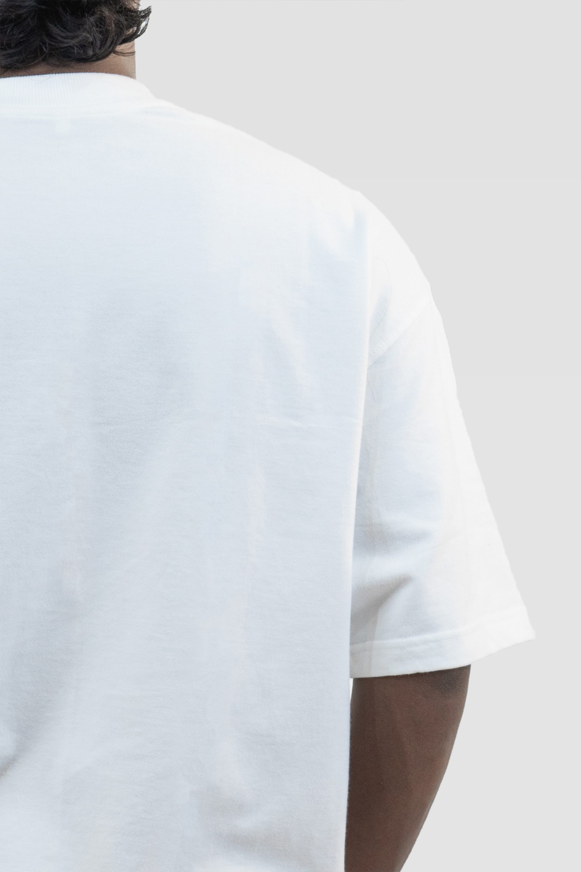 Close-up back detail of Harper Slein oversized t-shirt in Blank White, worn by a model, against a light background