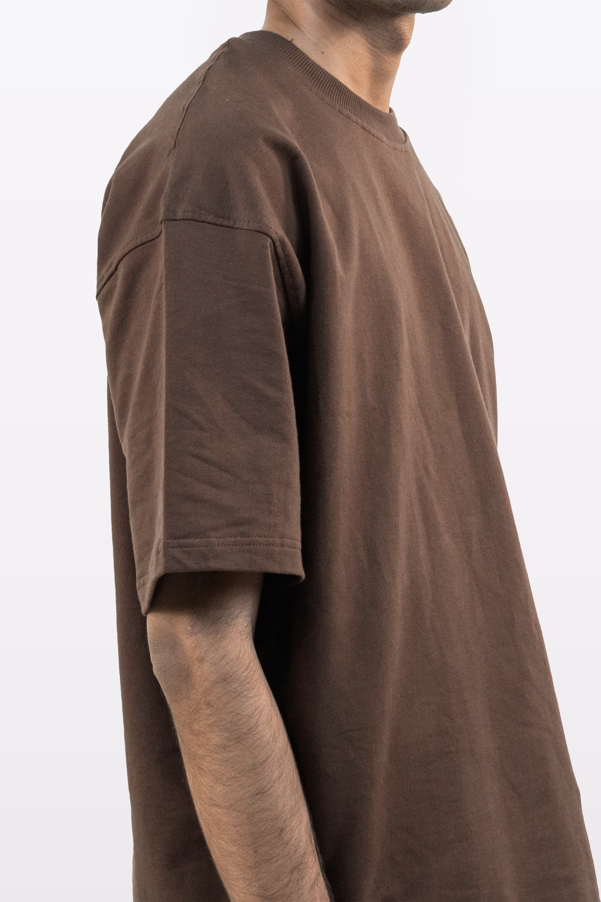 Side profile view of a model wearing Harper Slein oversized t-shirt in Cacao on a white background