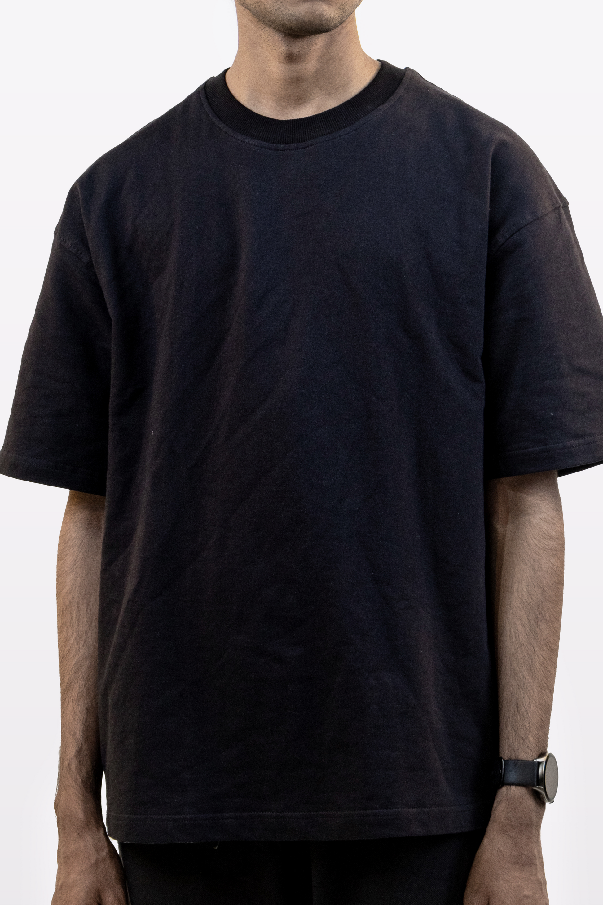 Cropped front detail of male model wearing Harper Slein oversized t-shirt in Classic Black on a white background