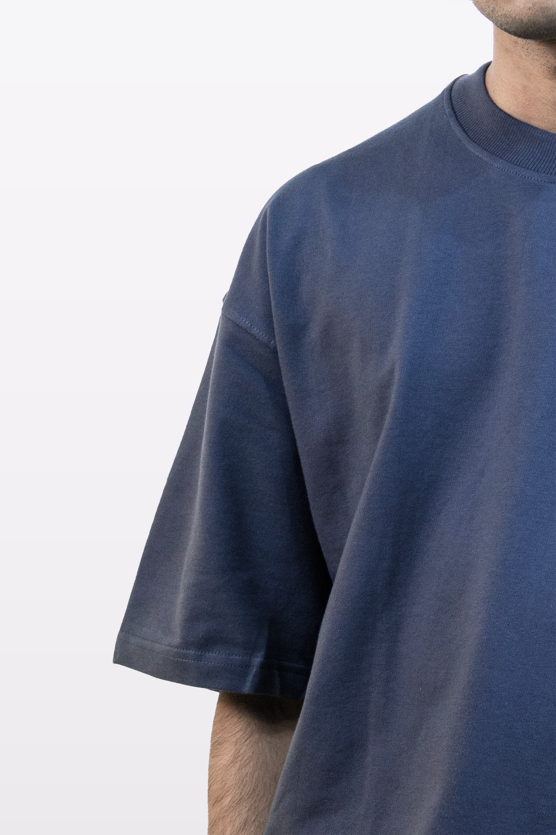 Upper body close-up of model wearing Harper Slein oversized t-shirt in Compass Blue, highlighting shoulder and chest area, on a white background