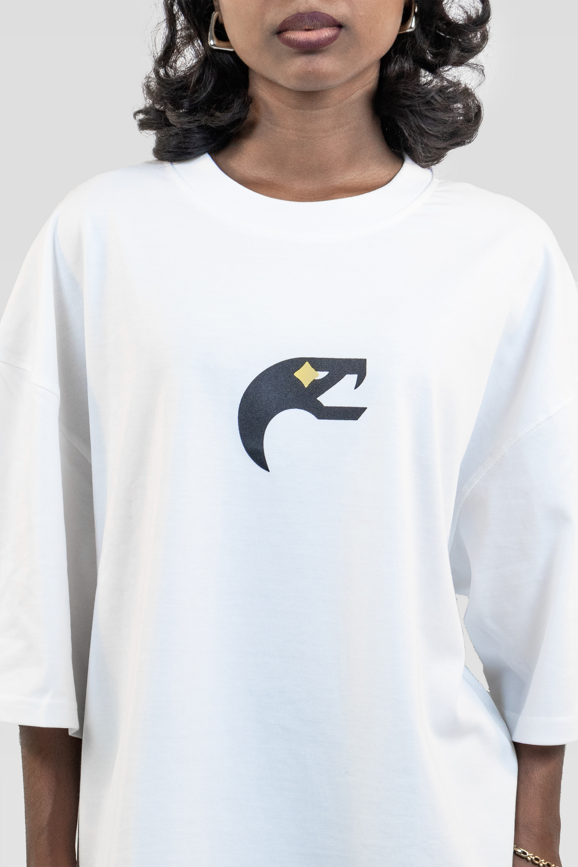 Close-up front view of the Harper Slein Urban Crew Collection Butterfly T-Shirt in white, featuring a black and yellow snake head logo printed on the chest, worn by a model against a light grey background.