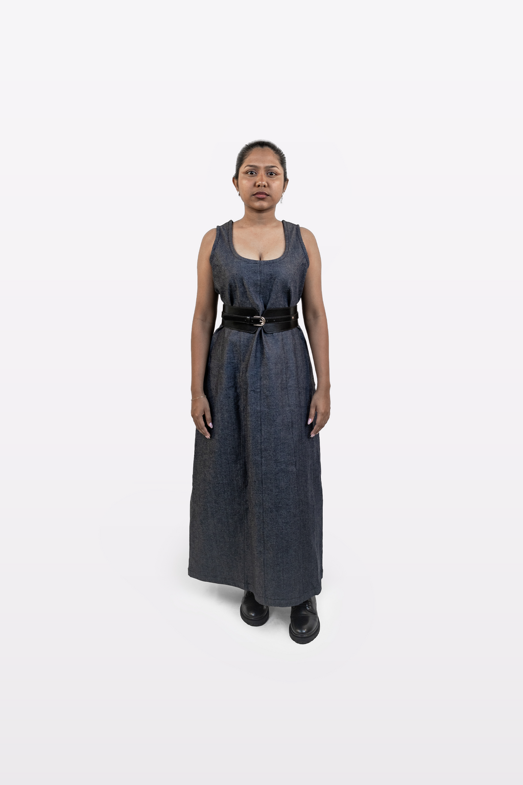 Model wearing Harper Slein sleeveless denim dress styled with a black belt, front view, on a white background
