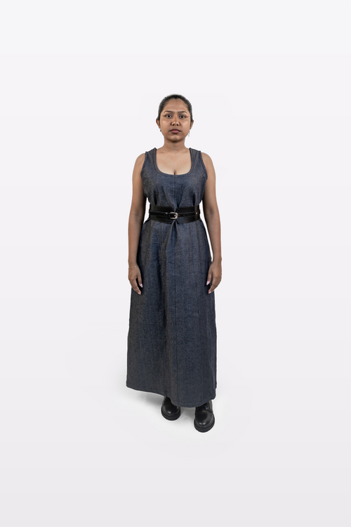 Model wearing Harper Slein sleeveless denim dress styled with a black belt, front view, on a white background
