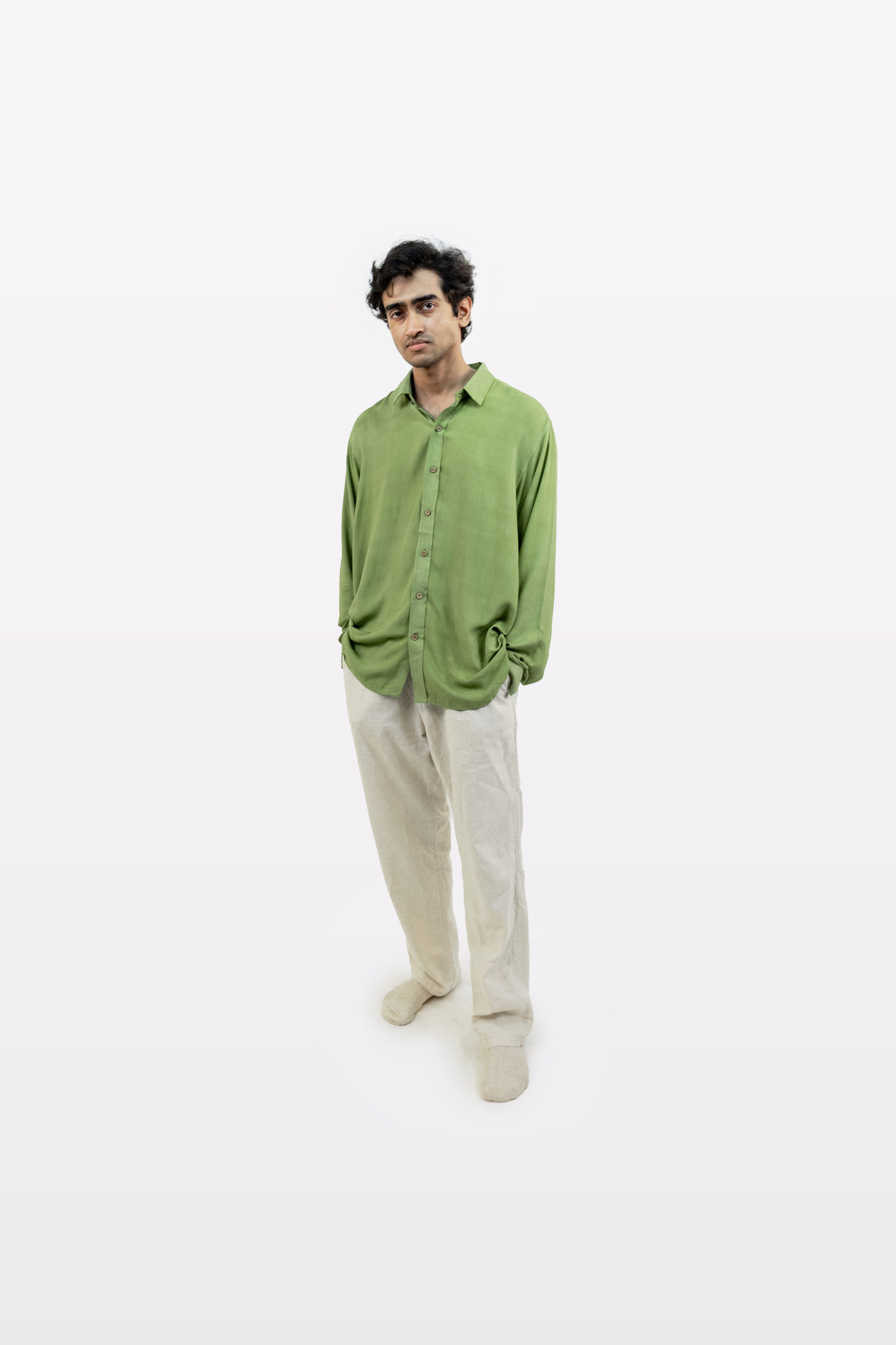 Full-body front view of a model wearing the Harper Slein Moss Shirt in green, paired with beige pants, against a white background