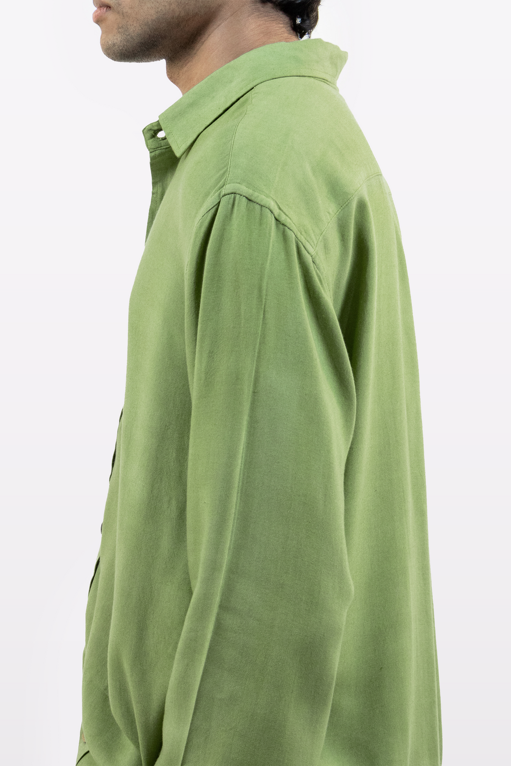A model wearing the Harper Slein Moss Shirt in green, side profile against a white background