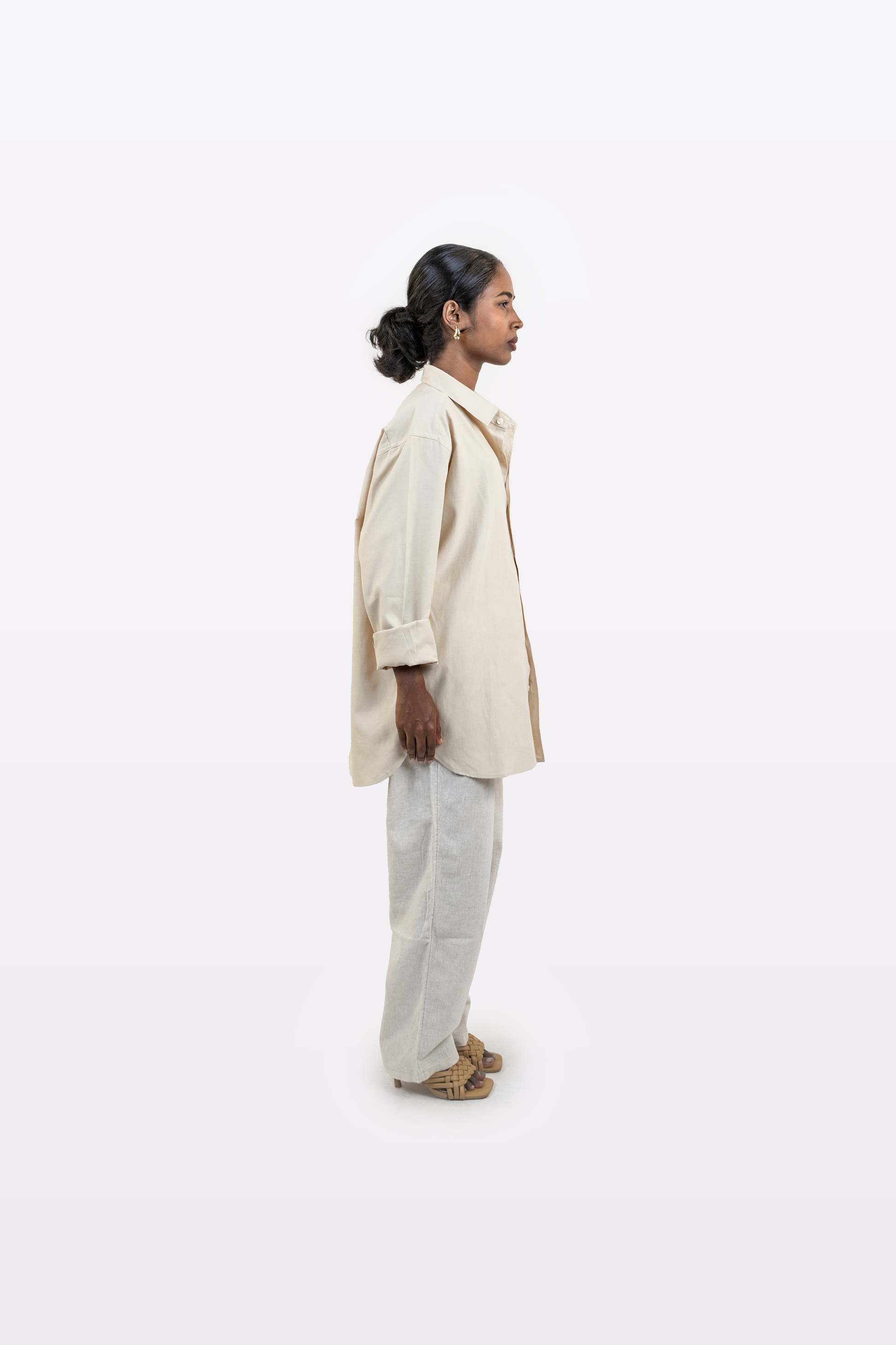 Full side profile of a model wearing the Harper Slein Off White Oxford Shirt with light trousers on a white background
