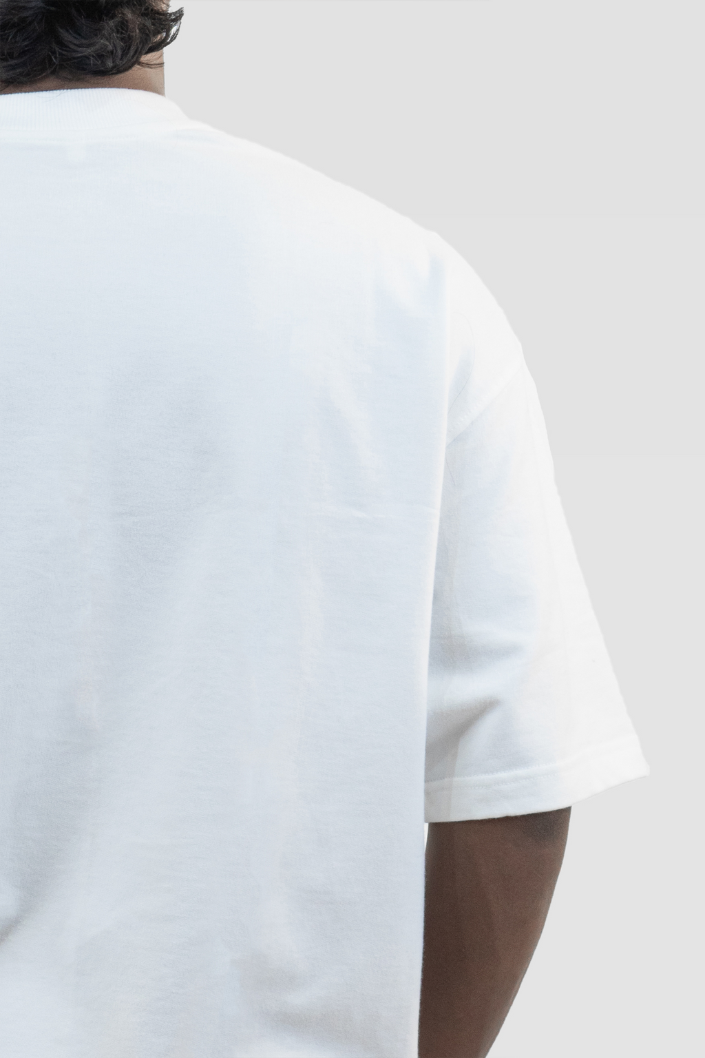 Close-up back detail of Harper Slein oversized t-shirt in Blank White, worn by a model, against a light background