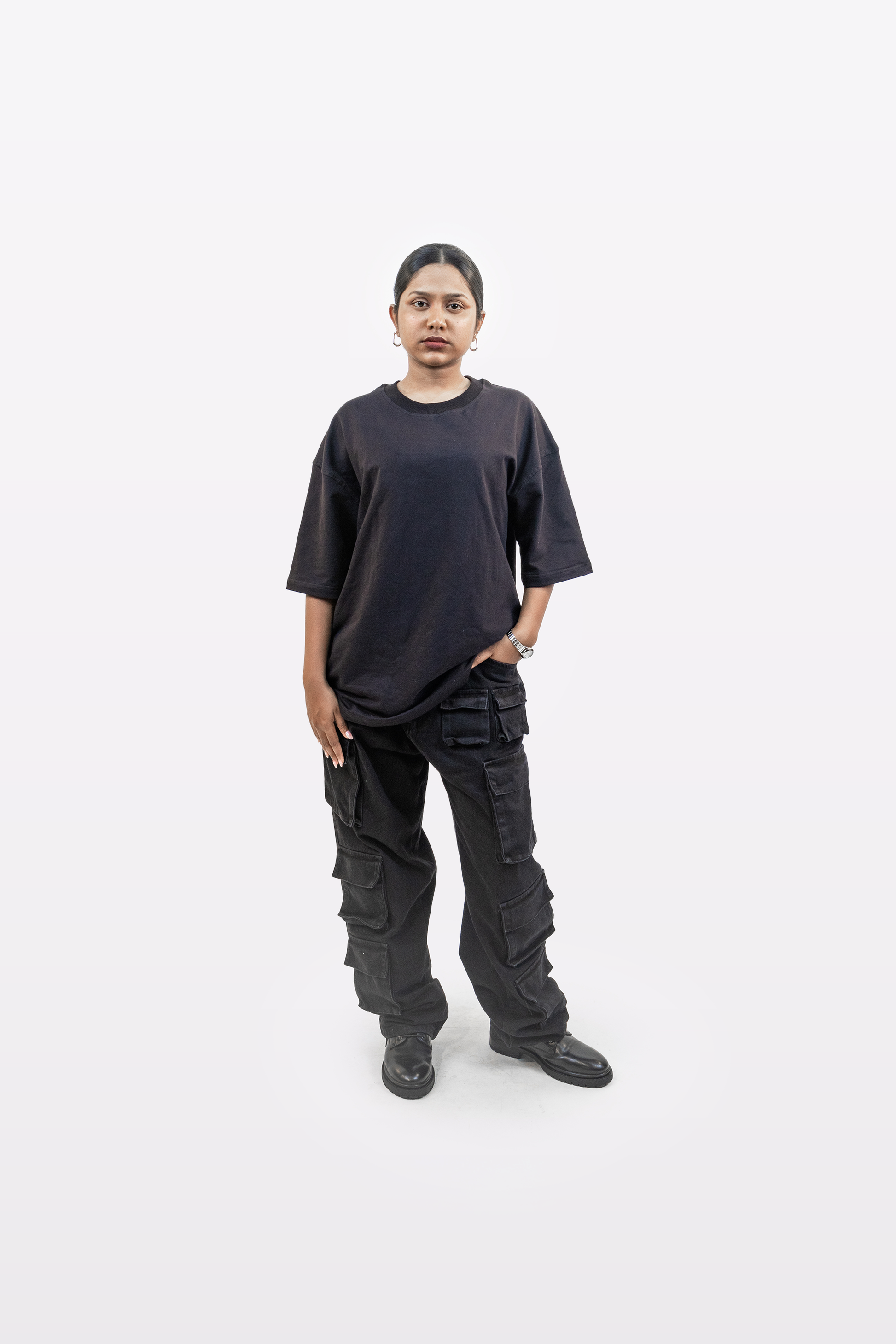 Female model in full body front view wearing Harper Slein oversized t-shirt in Classic Black styled with black cargo pants on a white background