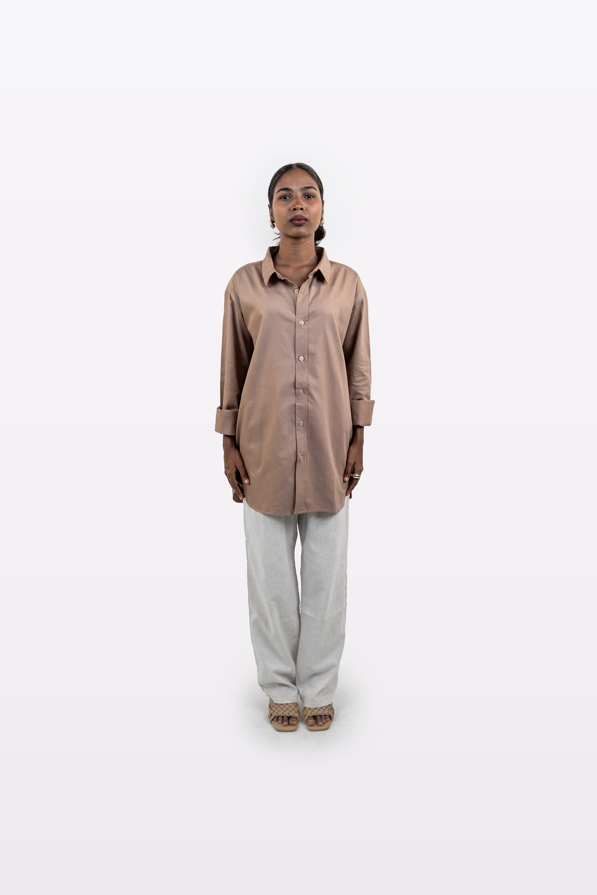 Front view of a model wearing the Harper Slein Brown Oxford Shirt with light trousers on a white background.