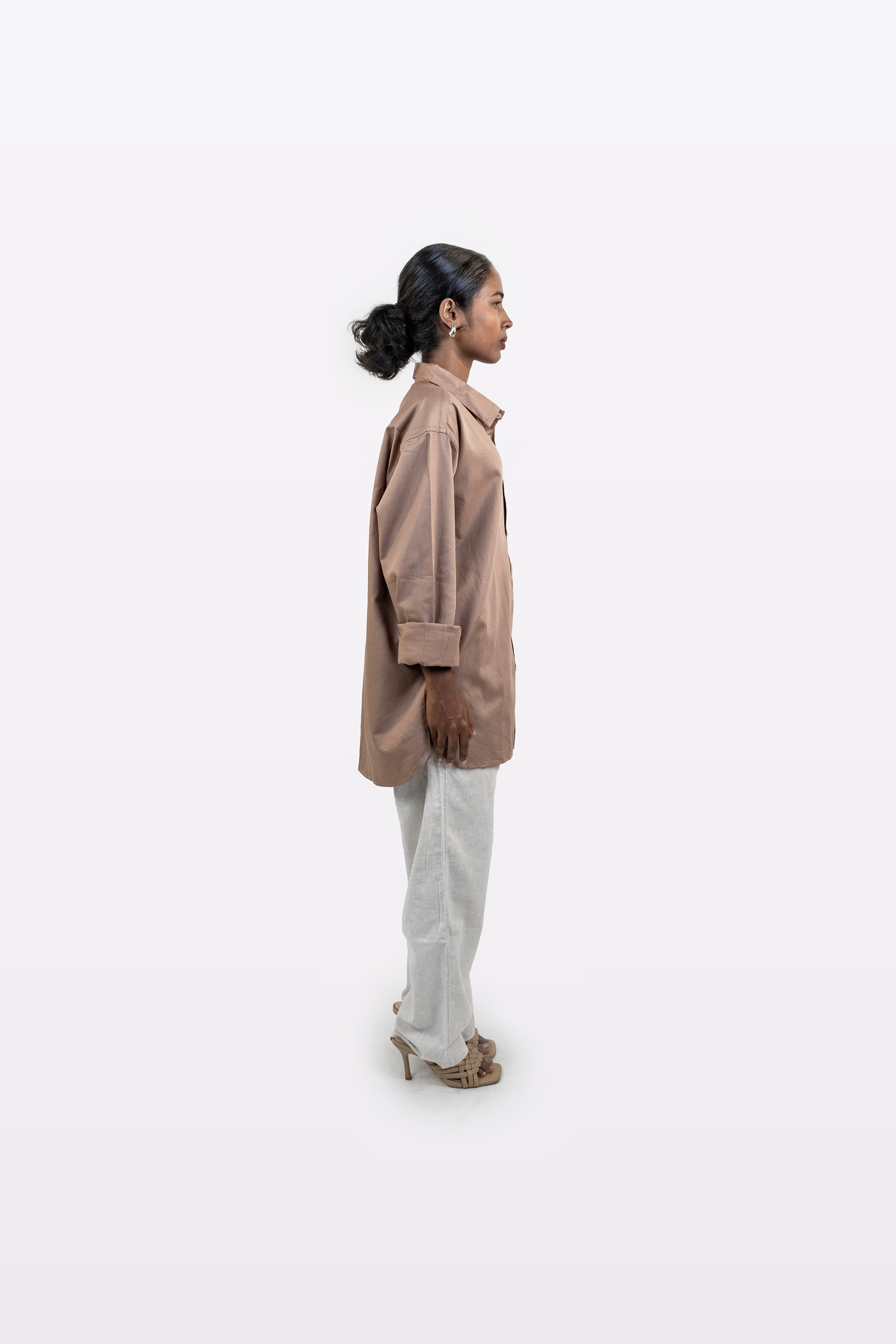 Left side view of a model wearing the Harper Slein Brown Oxford Shirt with light trousers on a white background.