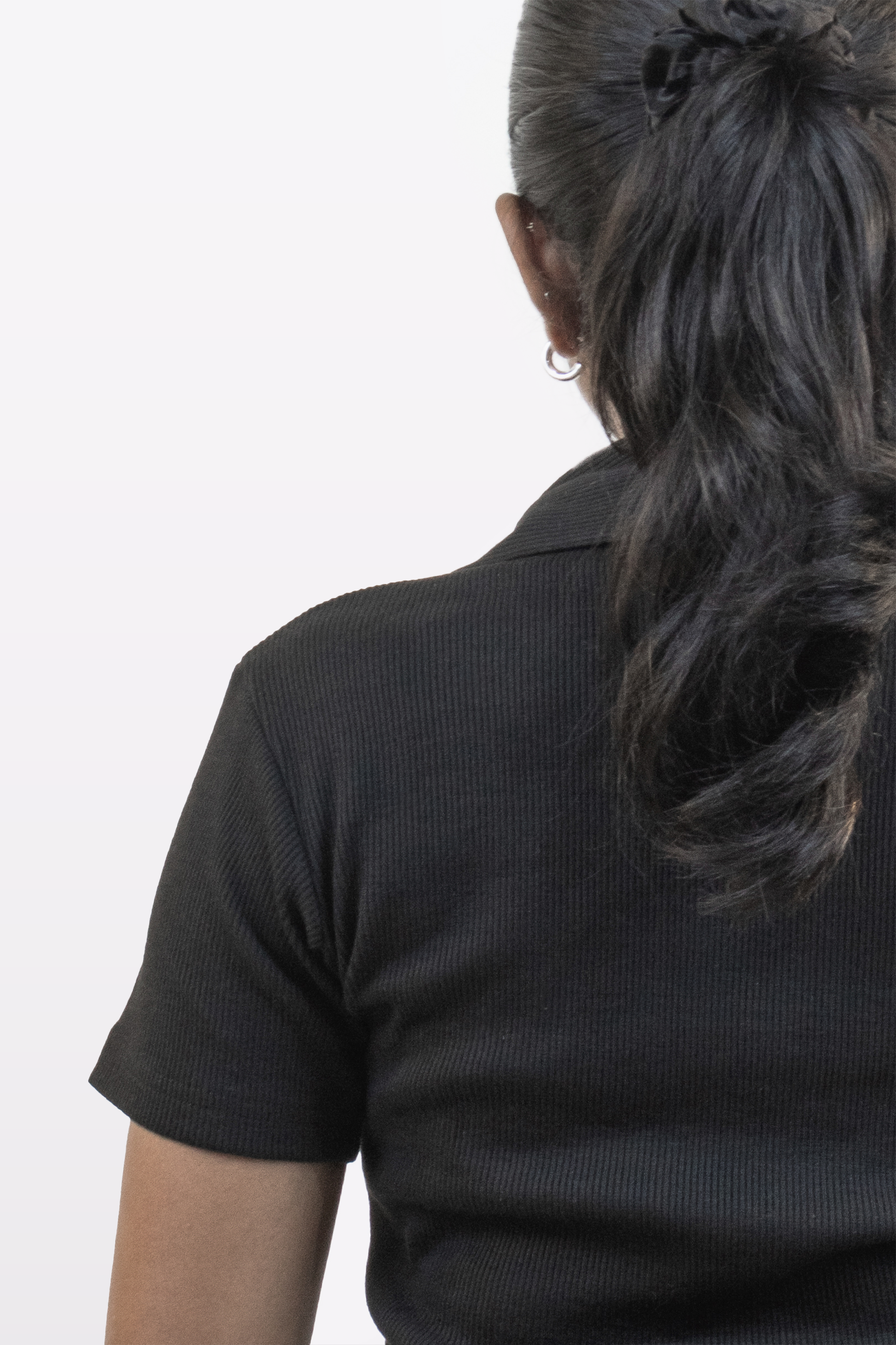 Close-up back view of Harper Slein ribbed black polo t-shirt, showing fabric texture and collar detail, on a white background
