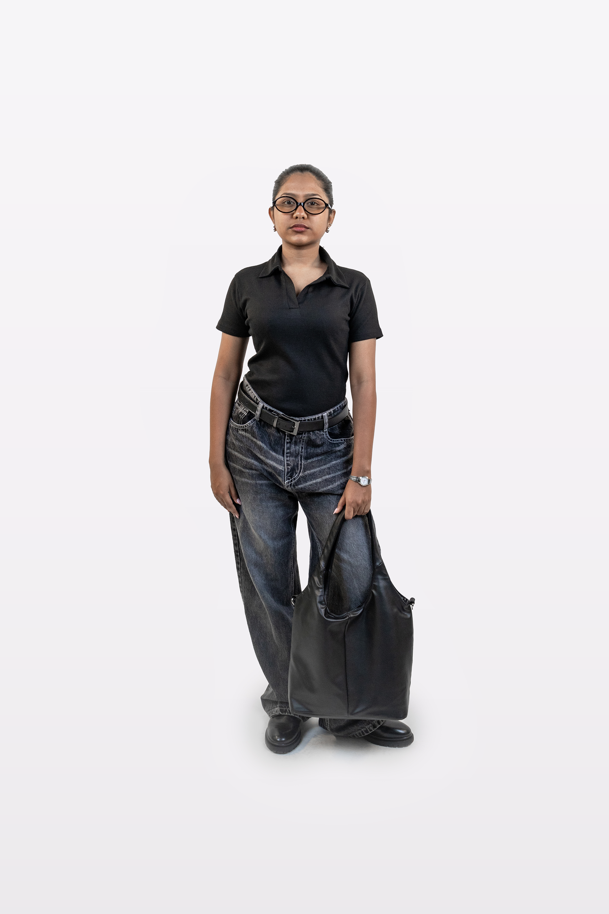 Model wearing Harper Slein ribbed black polo t-shirt styled with relaxed jeans and carrying a large black tote bag, on a white background