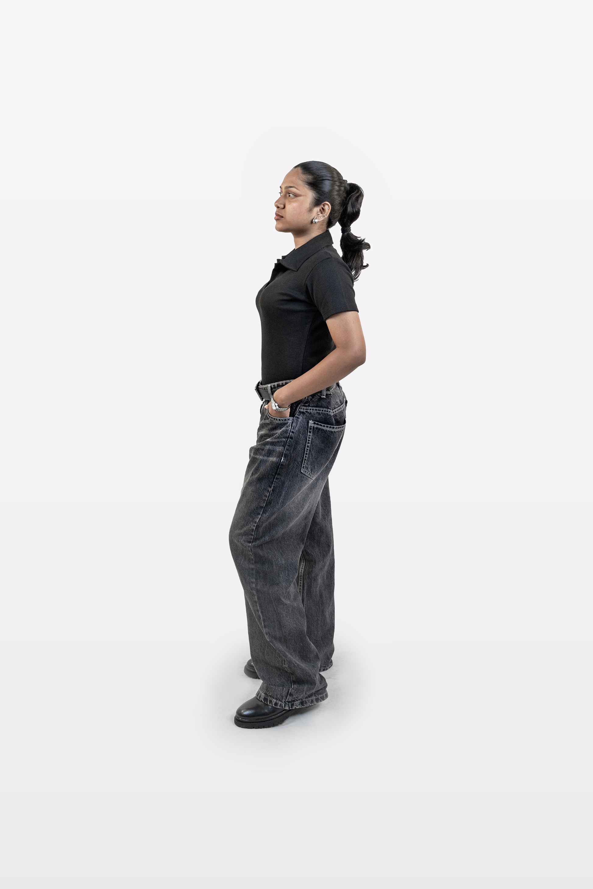 Model wearing Harper Slein ribbed black polo t-shirt styled with relaxed jeans, side profile view, on a white background