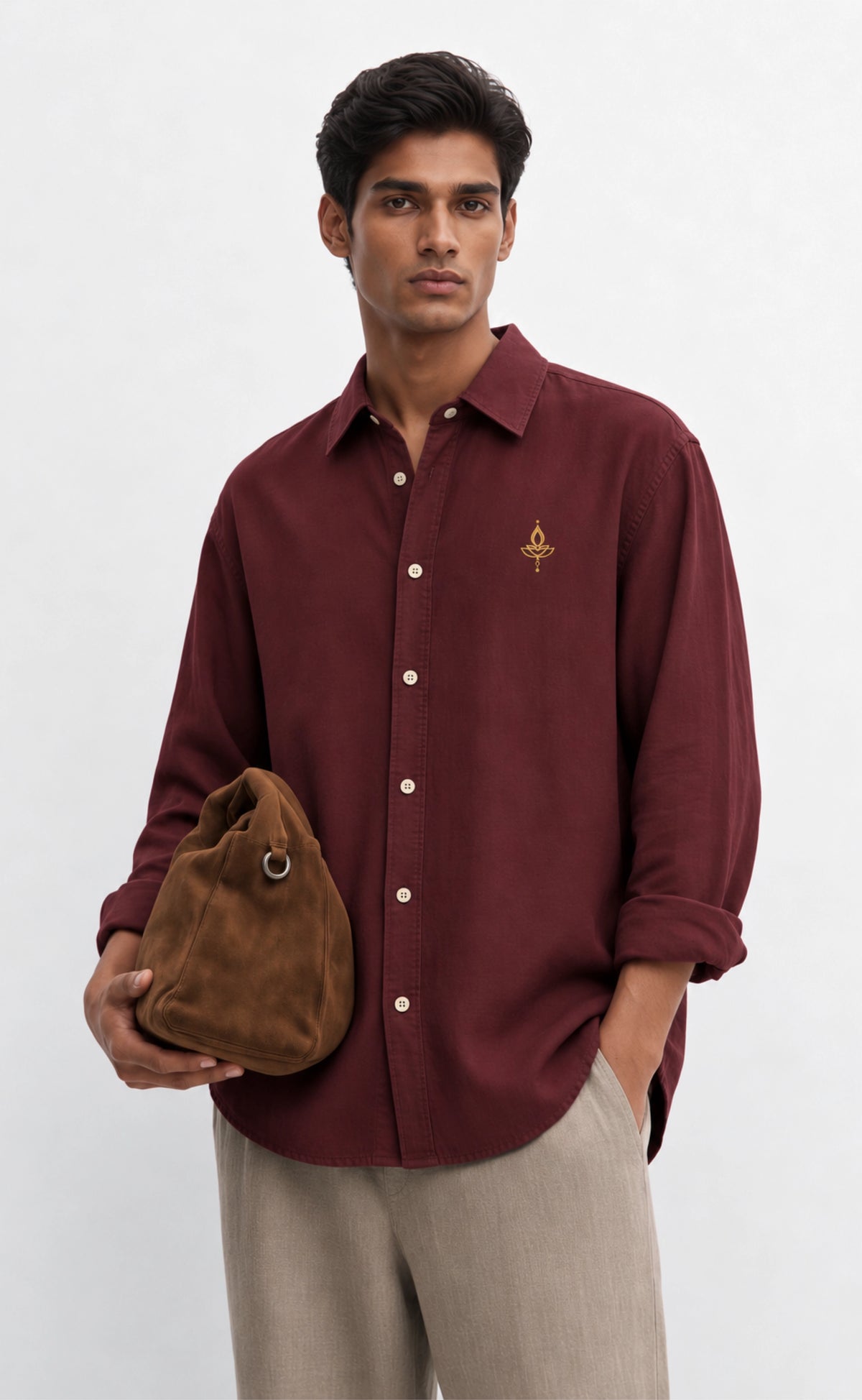 Front detail of the gold-tone diya chest motif on the burgundy cotton shirt