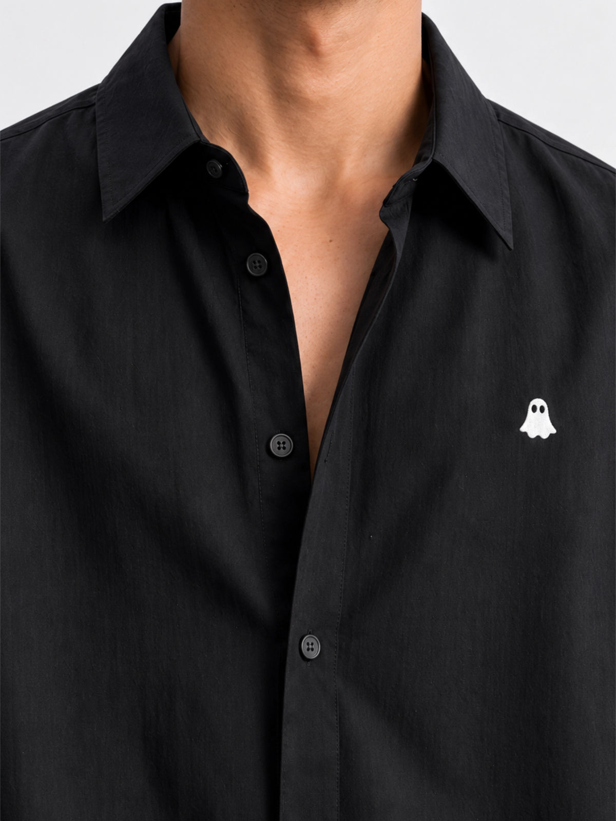 Close-up of white ghost embroidery and button front