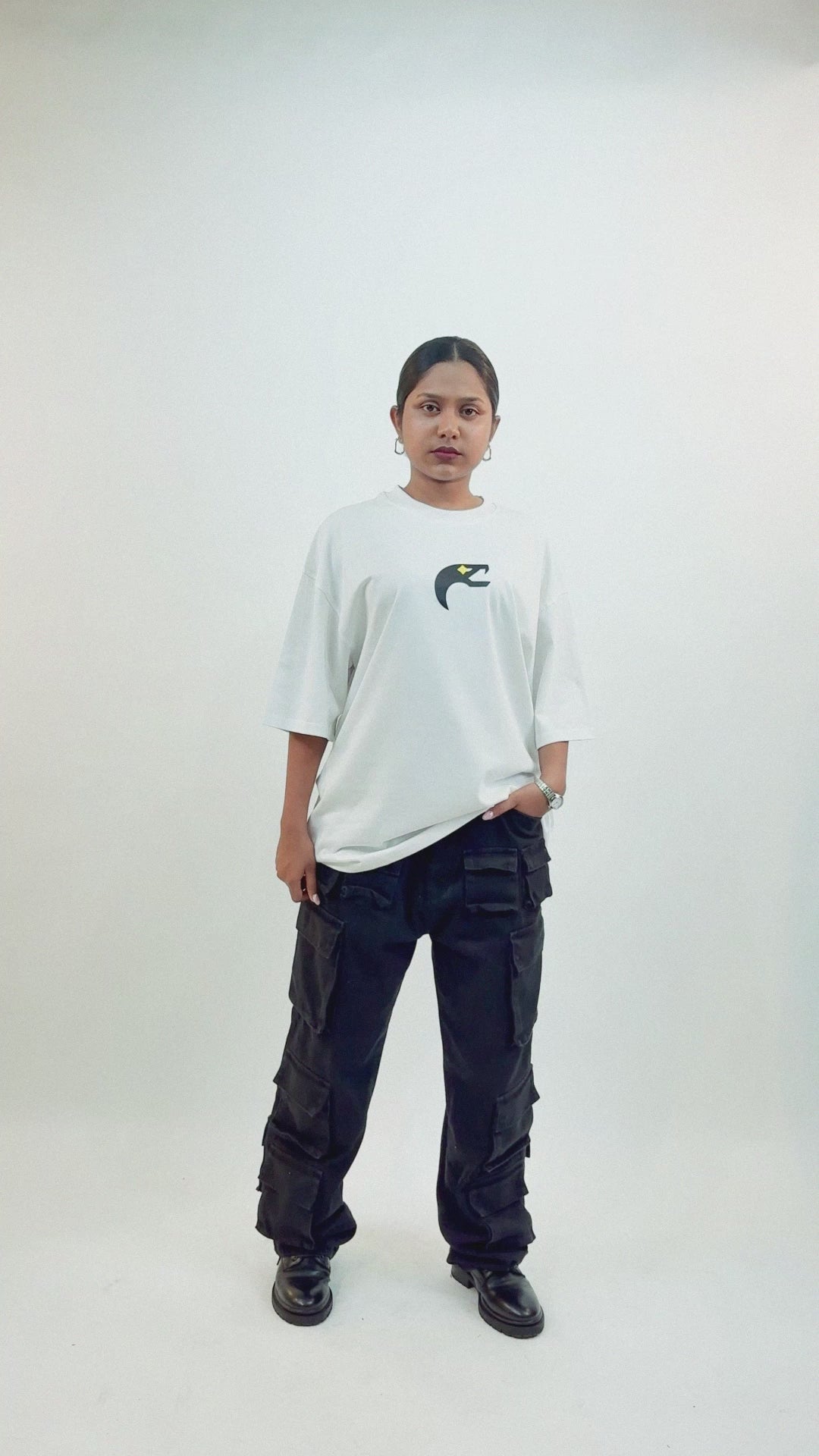 Harper Slein Urban Crew white oversized tee in premium cotton, featuring a small front logo and large intricate black butterfly gear graphic on the back, shown on female model styled with black cargo pants and pleated skirt, highlighting its bold and versatile streetwear style.