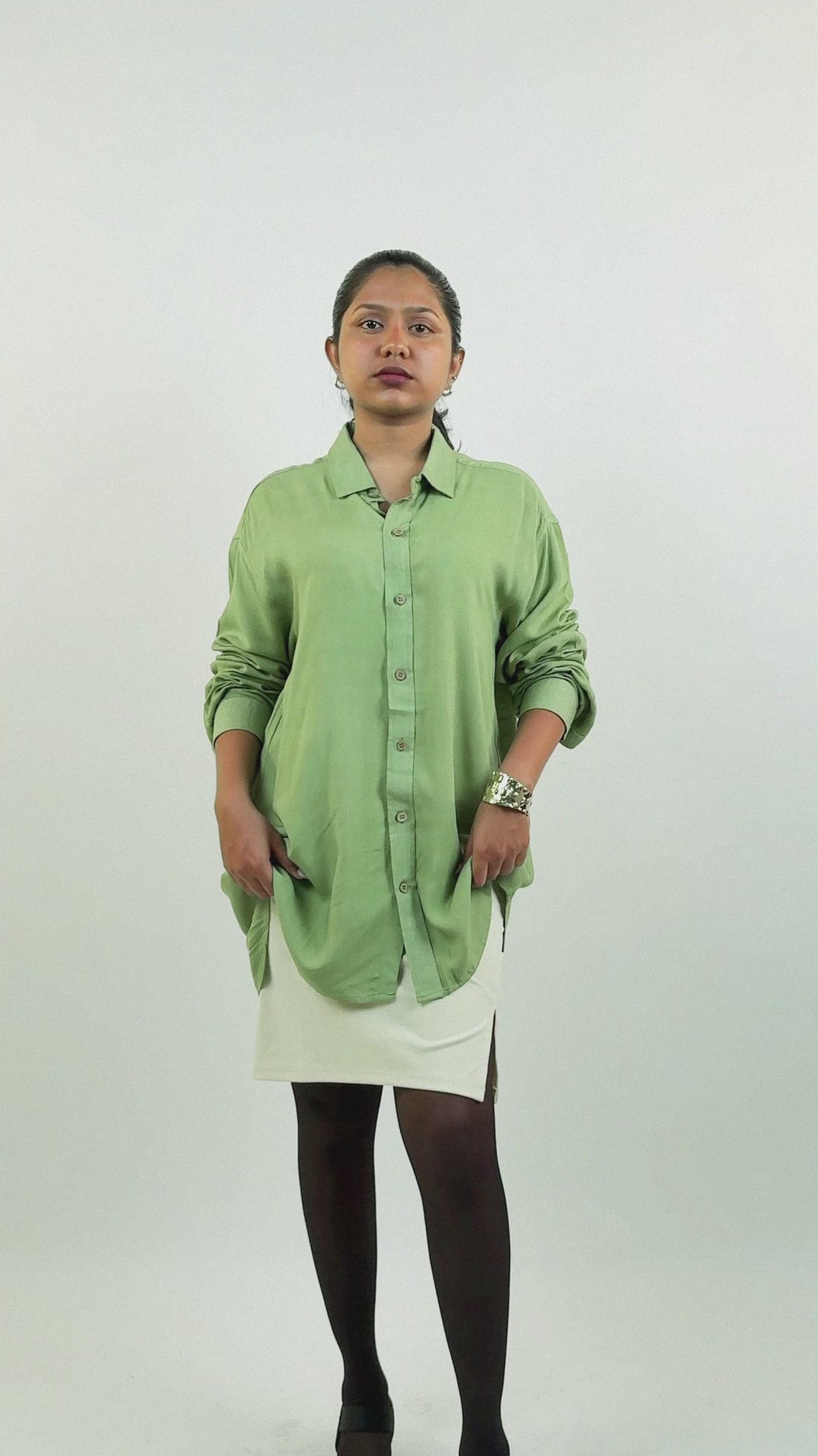 Harper Slein green oversized relaxed shirt with a soft drape, worn by model with rolled sleeves over a white skirt, creating a minimal and versatile look for everyday wear.